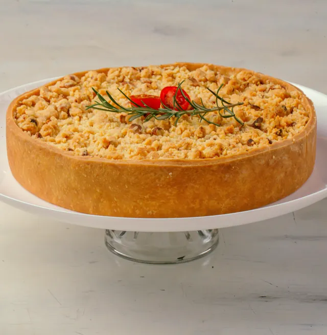 Torta de bacalhau com crosta crocante de castanhas, decorada com alecrim e pimenta